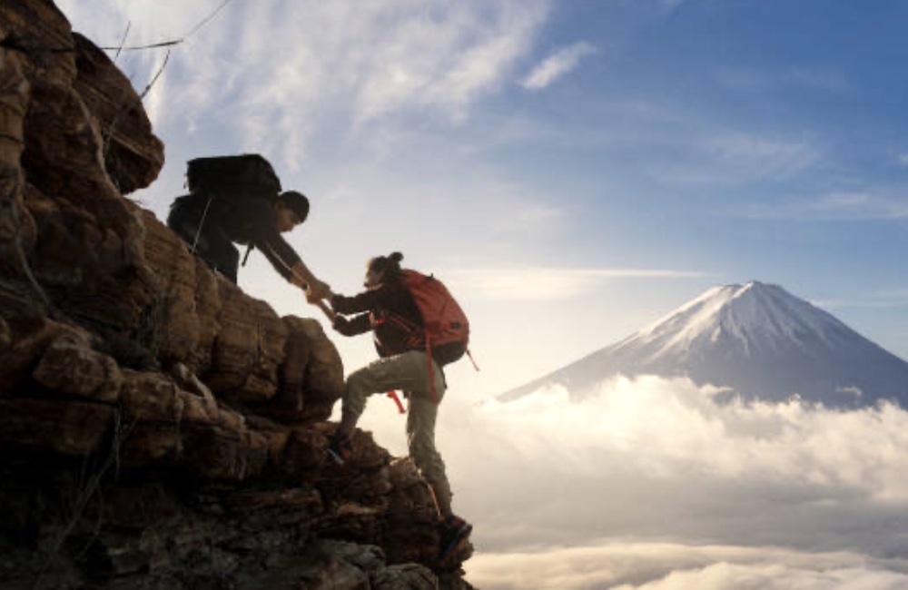 ガイドに導かれて山頂を目指すイメージ